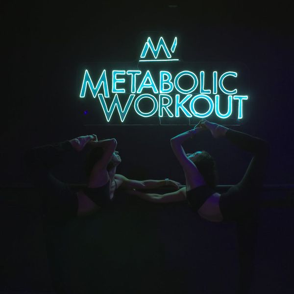 Inside a modern dark gym with neon violet lighting.