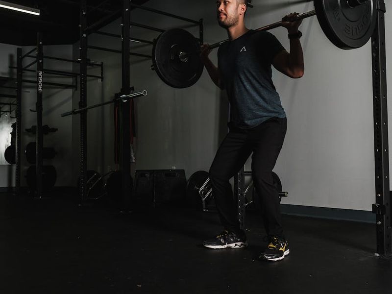 Man focusing on his workout in a dark gym setting.